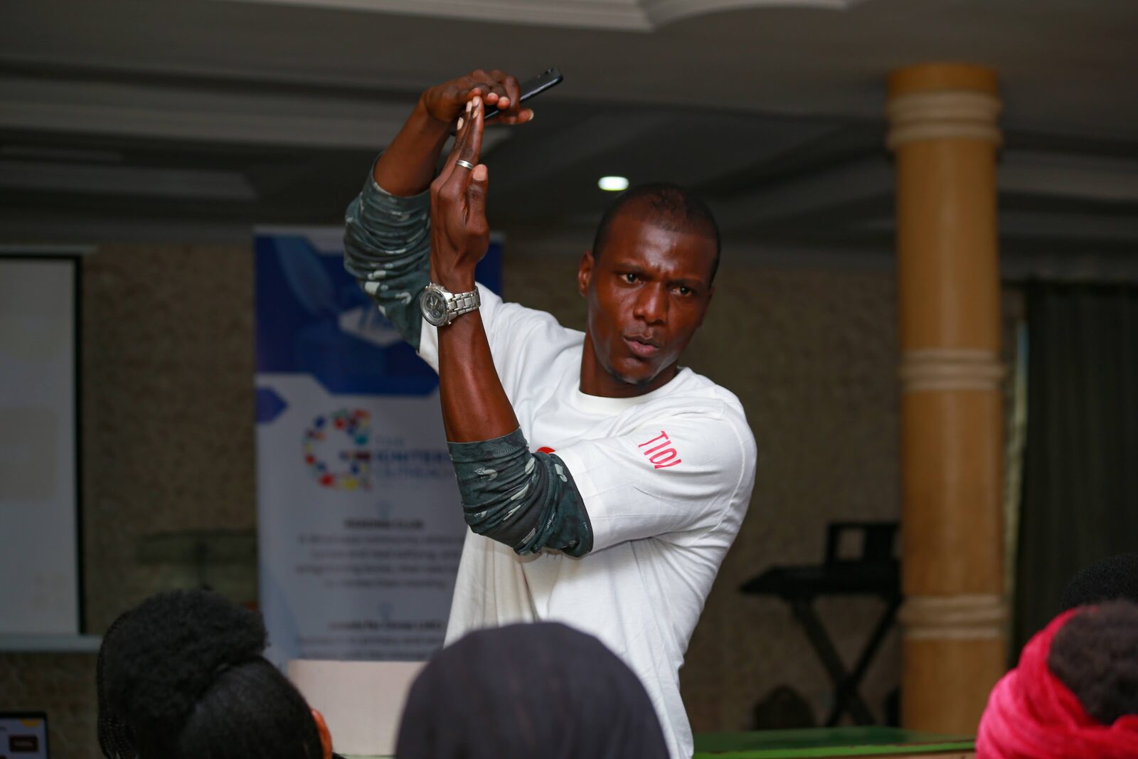 A speaker mid-gesture addressing an Igniters gathering